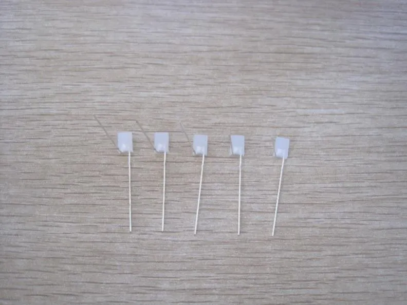 木纹桌面上并排五颗整形好的 LED：长脚保持竖直，短脚在灯珠根部折成 90 度向左伸出