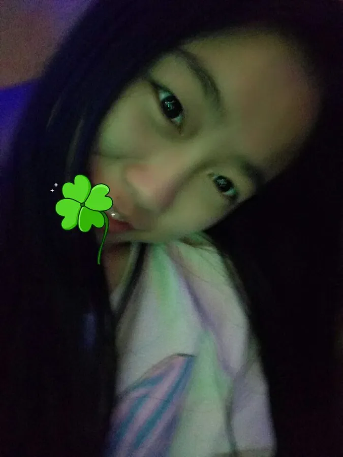 暗光下的自拍，画面上加了一枚四叶草贴纸