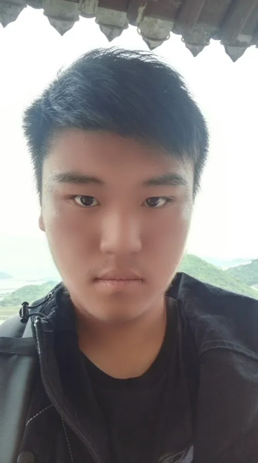 户外屋檐下的自拍：一名背着双肩包的男生看向镜头